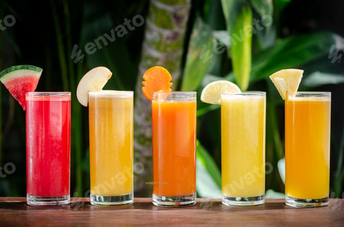 Preview: mixed fresh organic fruit juices glasses on sunny garden table