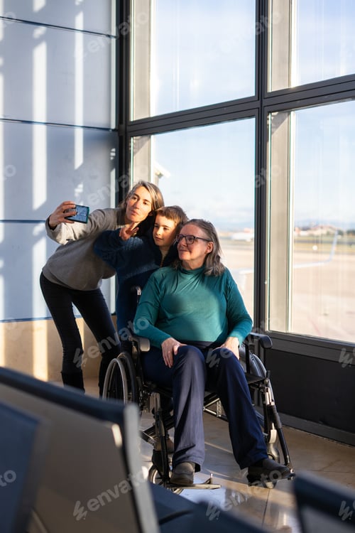 Preview: Family taking selfie at airport with grandmother in wheelchair