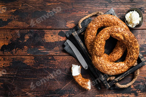 Preview: Stack of fresh baked Turkish simit bagel with kaymak. Wooden background. Top view. Copy space