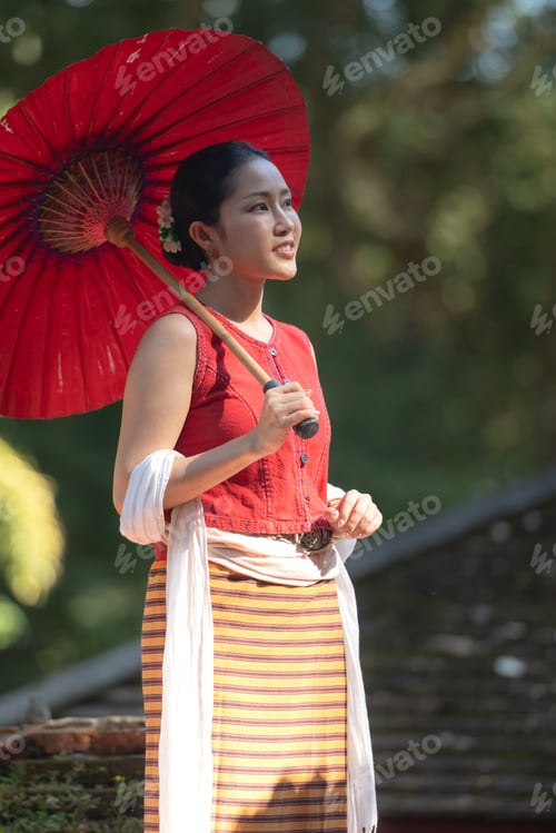 Preview: Asian woman wearing traditional Thai dress holding a red umbrella