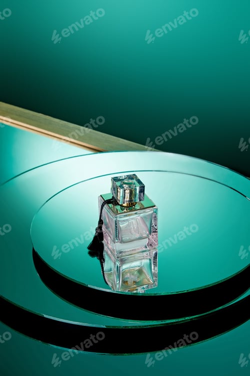 Preview: High angle view of purple perfume bottle on green round mirror surface