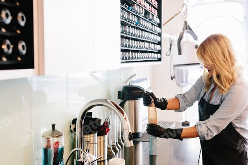 Preview: A woman working wearing gloves, cleaning the equipment at a hair salon.