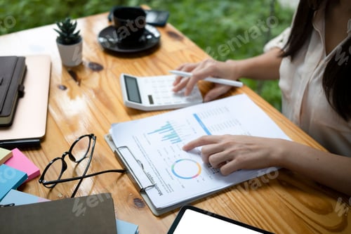 Preview: Accountant checking financial document and using calculator at office.
