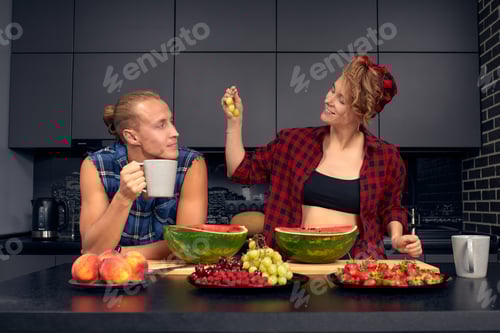 Preview: Happy couple standing in kitchen at home preparing together yummy dinner on first dating, spouses
