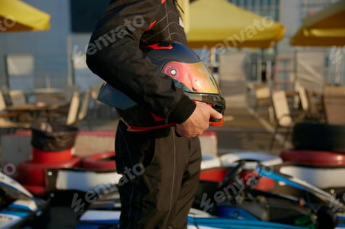 Preview: A racer getting ready for karting with a helmet held firmly in hand,