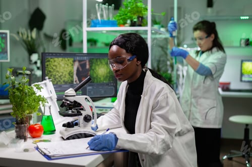 Preview: African american chemist woman writing medicine experiment results on clipboard