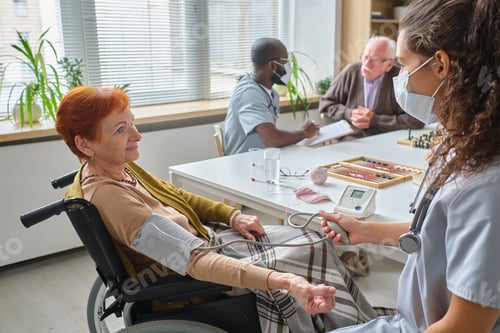 Preview: Nurse examining the elderly woman in nursing home