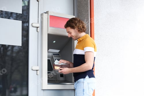 Preview: Young man with money near cash machine outdoors. Space for text