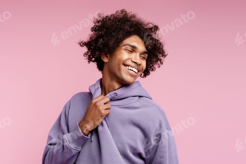 Preview: Smiling young man with curly hair feeling joy