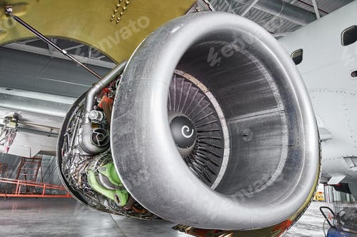 Preview: aircraft engine servicing - opened panels of a large engine of parked aircraft.