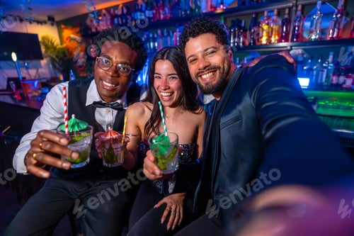 Preview: Friends taking selfie while drinking cocktails at the bar