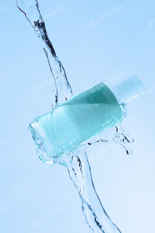 Vista previa: Vertical shot of a blue beauty product under the running water on a blue background