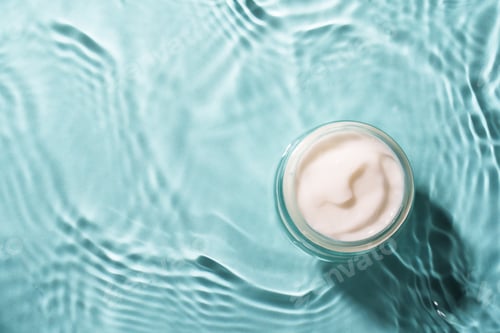 Preview: Cream jar in the water on blue background.