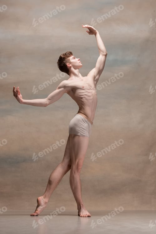 Preview: The male ballet dancer posing over gray background