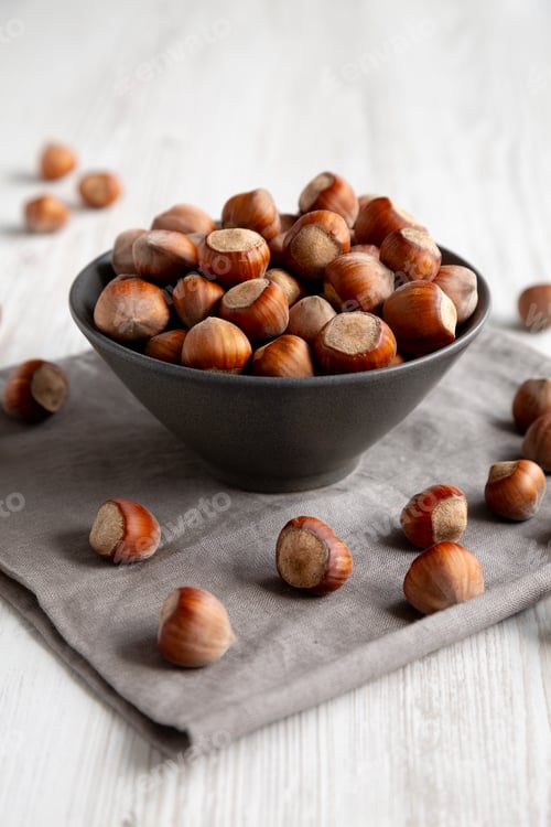 Preview: Organic Raw Hazelnuts in a Bowl, side view. Close-up.