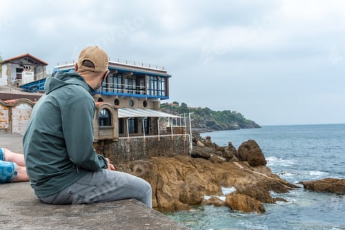 Preview: A young man looking at the sea from the maritime port of the Lekeitio municipality