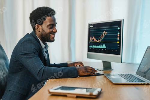 Preview: Man Analyzes Financial Charts at Desk