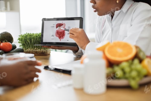 Preview: Tablet with GI tract picture being held by woman at doctor's