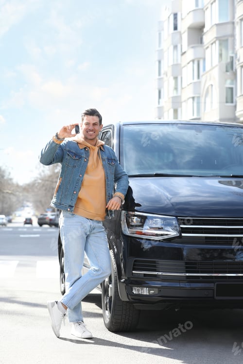 Preview: Man with key near car on city street. Buying new auto