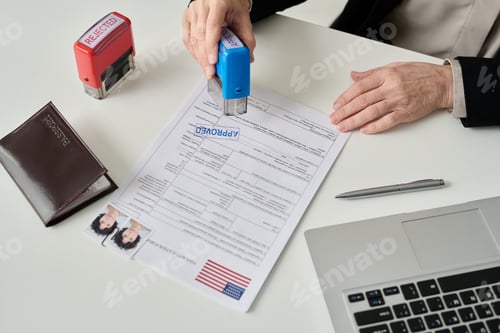 Preview: Worker putting approved stamp on visa application