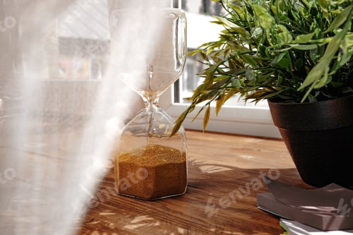Preview: Hourglass with golden sand pouring inside on wooden background