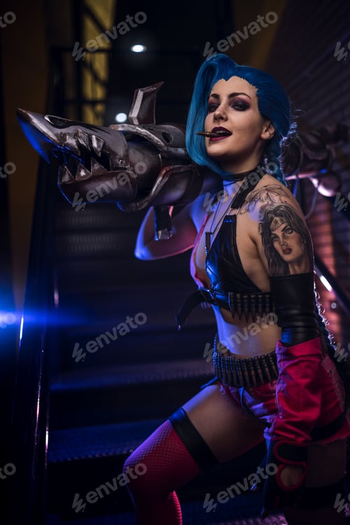 Preview: Vertical shot of a young female with tattoos standing on the stairs with a shark figure
