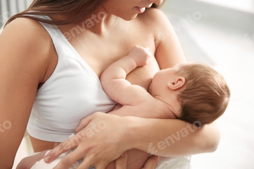 Preview: Young woman breastfeeding her baby on blurred background, closeup