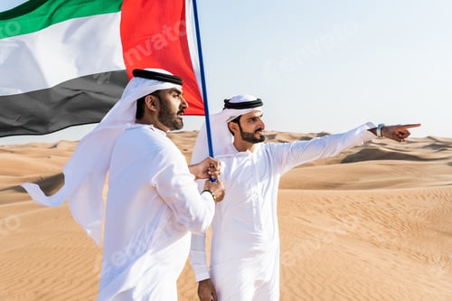 Preview: Two middle-eastern emirati men wearing arab kandura bonding in the desert