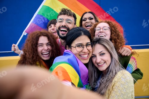Preview: Selfie of a LGBT group of young people celebrating gay pride day holding rainbow flag together