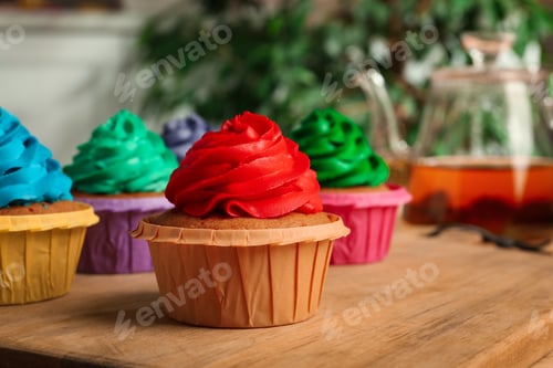 Preview: Delicious cupcakes with cream on wooden table, closeup