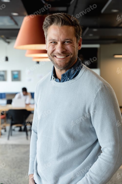 Preview: Portrait of smiling caucasian mid adult businessman at creative office