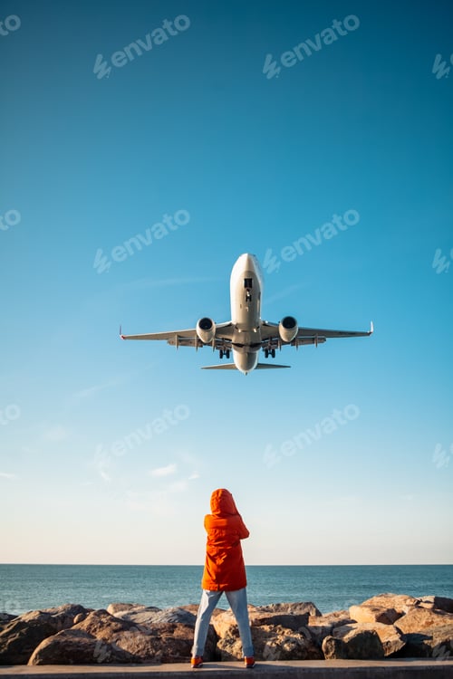 Preview: woman filming plane landing on phone