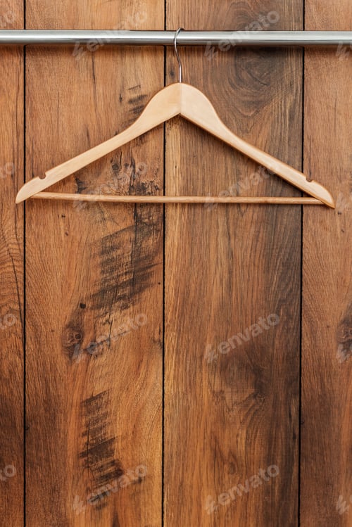 Preview: Wooden coat hanger. Close-up of hanger hanging against wooden grain