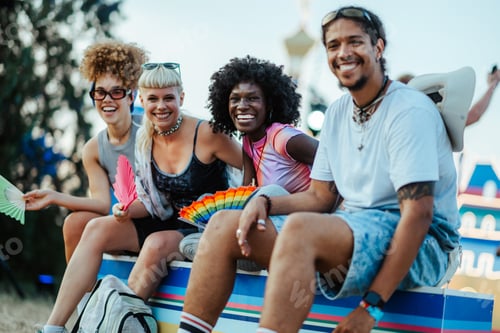Preview: Happy friends enjoying music festival with colorful hand fans