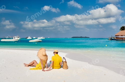 Preview: Couple in yellow on tropical beach at Maldives