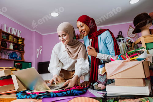 Preview: Muslim women managing online fashion business on laptop