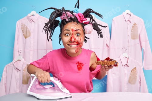 Preview: Happy busy woman eats delicious homemade pie and irons laundry bites lips and stares surprised at