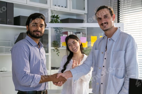 Preview: Group of multiethnic young business friends gathered in a modern office