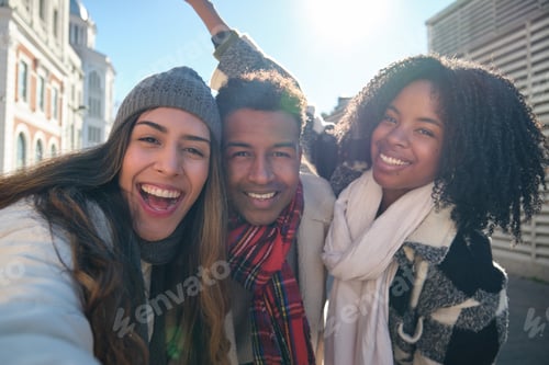 Preview: Happy multi ethnic friends taking selfie while walking in the city center