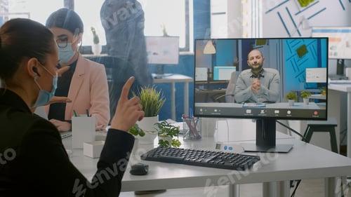 Preview: Freelancer wearing protective face mask during online videocall