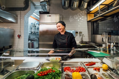 Preview: Joyful cafe worker prepares salad. Catering kitchen work.