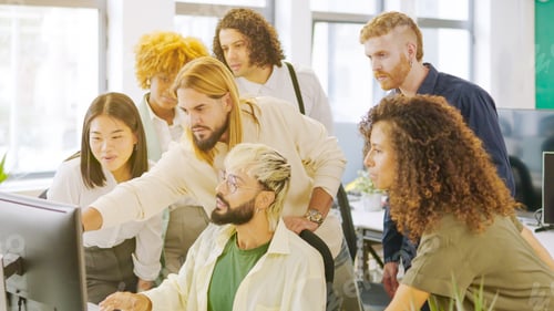 Preview: Coworkers talking while looking at a one computer screen