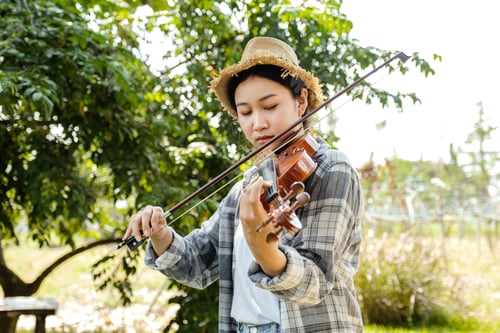 Preview: Close-up portrait of Young Asia woman music violinist play the violin, relax in the garden