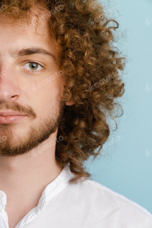 Preview: Young curly man with ginger hair posing and looking at camera