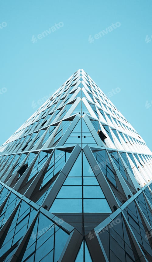 Preview: Low angle shot of a modern glass building in the blue sky background