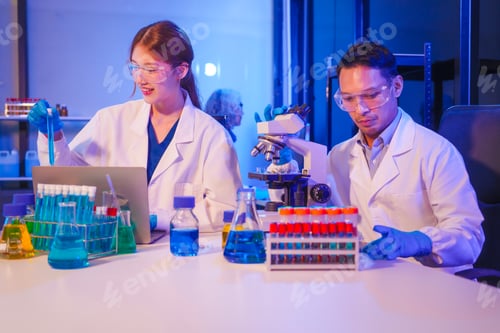 Preview: Two Asian men and women sit at a table in a laboratory, conducting research on liquids. They use