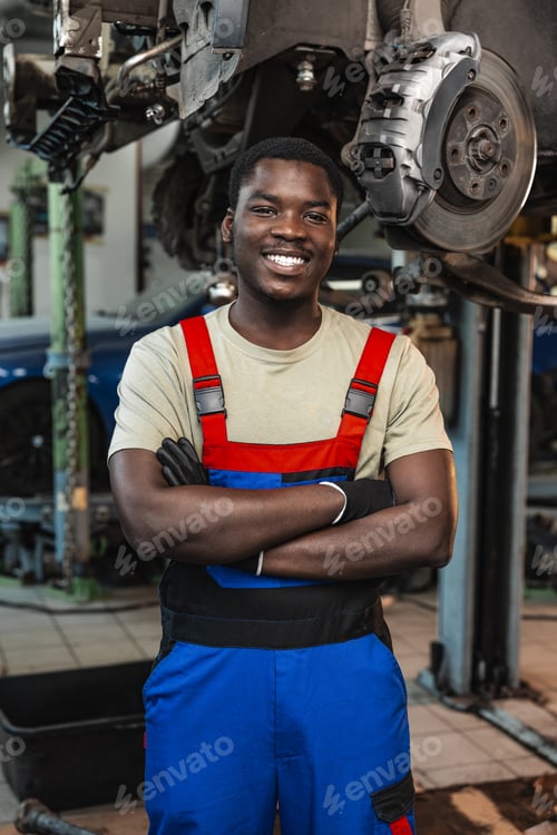 Preview: Portrait of young african man car service worker wearing uniform standing in garage