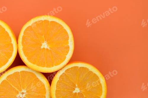 Preview: Top view of a several orange fruit slices on bright background in orange color. A sat