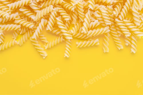 Preview: Scattered Raw Pasta Fusilli Isolated On Yellow Background. Food Background, Italian Cuisine
