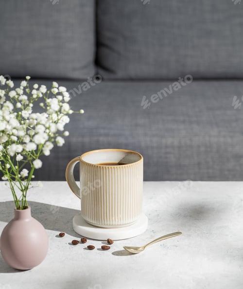 Preview: Ceramic cup of black coffee on marble table, pink vase with bouquet of gypsophila